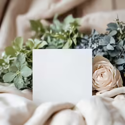a white square card next to some flowers