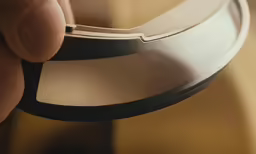 a hand holding a mirror near the surface