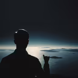 man in black shirt looking at ocean with icebergs