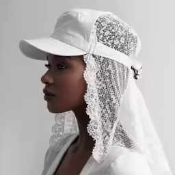 a women wearing a white hat with a veil on it