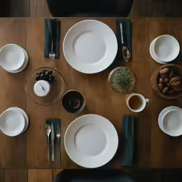a table topped with plates and glasses next to utensils