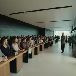 a row of tables filled with people sitting in front of each other