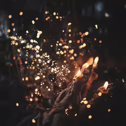 a person holds a lit candle out for the night