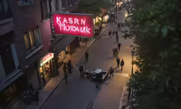 a crowd of people walking on a street near a building