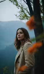 woman standing near trees looking at mountains with orange flowers