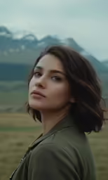 a woman is looking at something while standing in the field