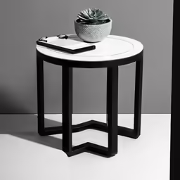 there is a small table with some pens and a potted plant on it