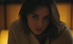 a woman sitting in front of a candle lit room