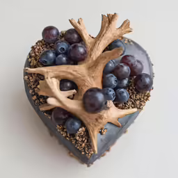 the heart shaped cake has been decorated with grapes