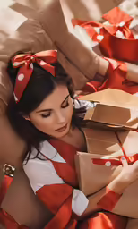 a woman sitting in a chair while holding two gifts