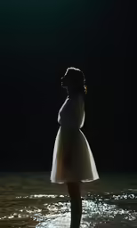 a person standing in the water by a light