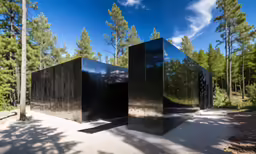 several large black boxes sitting in the woods