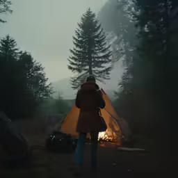 a woman standing in front of an orange tent