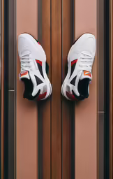 a pair of white shoes hanging on a wall