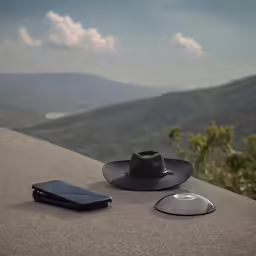 a cowboy hat sitting on top of a wall next to an ipod