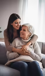 an older woman is hugging her younger woman on the couch