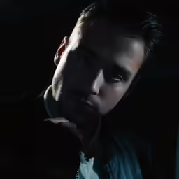 a man in a jacket standing by a window