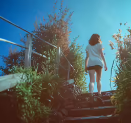 a woman in white walking down a set of stairs