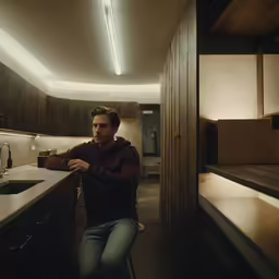 a man in a kitchen that is inside of a home