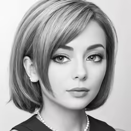 a black and white photo of a woman wearing pearls