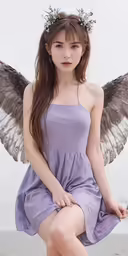 girl with fairy wings sits on the beach