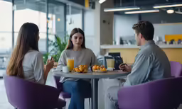 three people sitting at a table having breakfast together