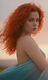 woman with red hair sitting in the grass