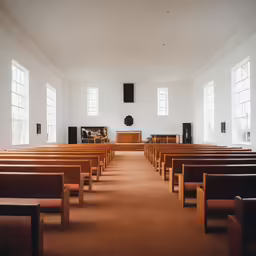 empty wooden chairs in front of pews inside an all white church