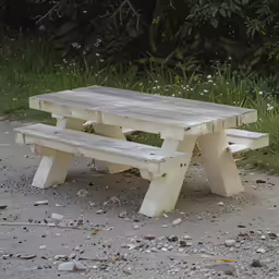 a white picnic table set up on a gravel path
