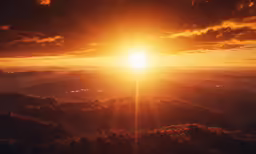 the sun sets over mountains as seen from an airplane