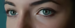 a woman with large blue eyes and a serious look