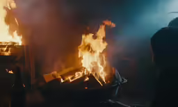 an outdoor grill on the ground with fire