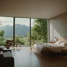 the bed is in front of huge glass windows