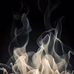 smoke swirls across the surface on black background
