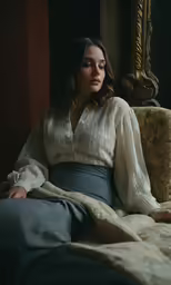 a pregnant woman sits on the bed while wearing her underwear