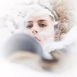 a woman with snow covered hood and hair