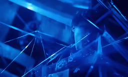 the man in the blue room is looking into the glass