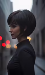 a woman with a short black haircut stands in a city street