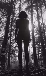 black and white photo of woman in front of trees