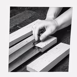 a person with their hands resting on a piece of wood
