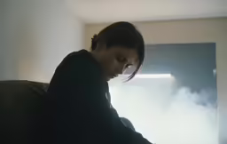a woman in a black jacket is playing on a phone