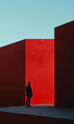 an man standing next to a red wall