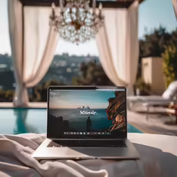 a laptop on the edge of a bed in front of a window