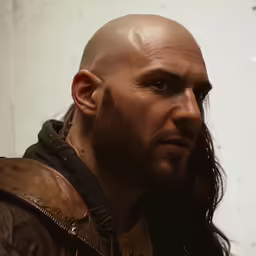 a bald male with long hair wearing a leather jacket