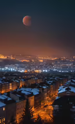 the night view of a large city with snow covered roofs