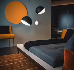 two round lights are hanging above a modern bedroom