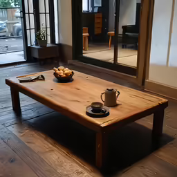 a table with a bowl of fruit and a coffee cup on it