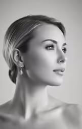 a woman with big earrings poses in a black and white photo