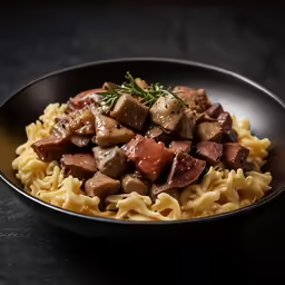 a black plate topped with pasta and meat