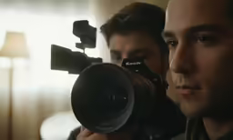 a man holding a camera near his face